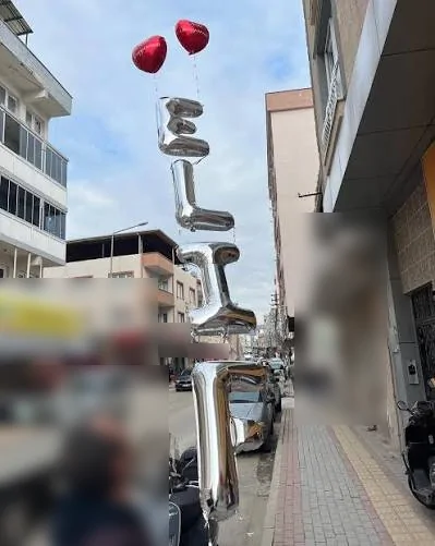 Şehir içinde yükselen gümüş harfli isim zinciri Şehir sokağında gökyüzüne doğru yükselen gümüş harf balonu zinciri